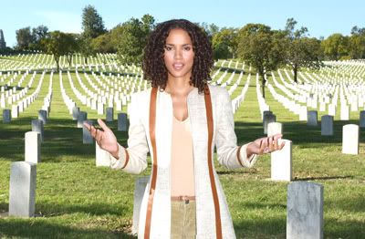 Stylized photo of Halle Berry standing in front of rows of white tombstones with her palms facing up