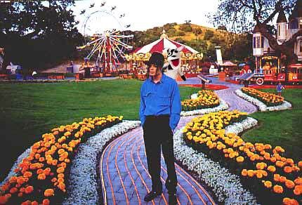 picture of Micheal Jackson standing on a path at Neverland ranch with the Pets.com sock puppet on his shoulder