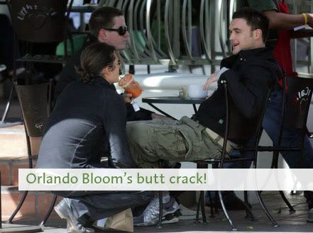 obscured picture of Orland Bloom crouching and talking to his friends sitting at a table with the caption: Orlando Bloom's Butt crack!