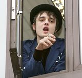Pete Doherty hanging out a window to smoke a cigarette
