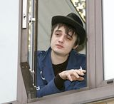 Pete Doherty hanging out a window to smoke a cigarette