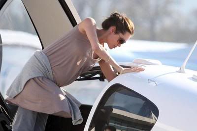 Angelina Jolie climbing into a plane with her skinny spider arms showing