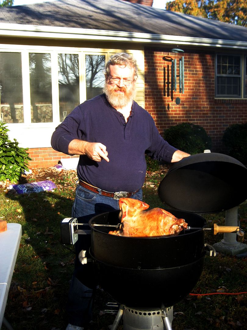 Hubby proudly points out his delicious turkey spinning on the grill.