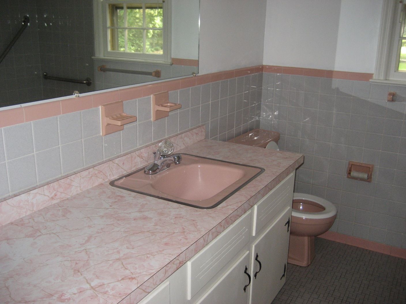 And just down the hallway is the worlds most beautiful bathroom! Its PINK!  And like the kitchen, the formica countertops are in pristine condition. The tile floors and wall are also in beautiful shape. What could be better than a cast-iron, 1960s Kohler bathtub? Nothing! Unless its a PINK cast-iron, 1960s Kohler bathtub!