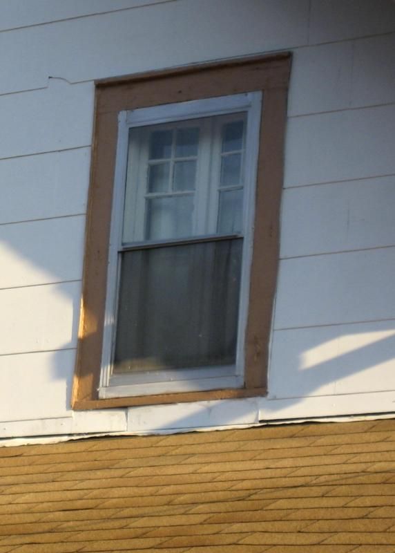 Notice the original wooden casement windows are still in place, now hidden behind double-hung aluminum storm windows. 