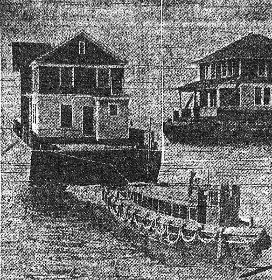 The houses, being floated in by barge, in 1921. 