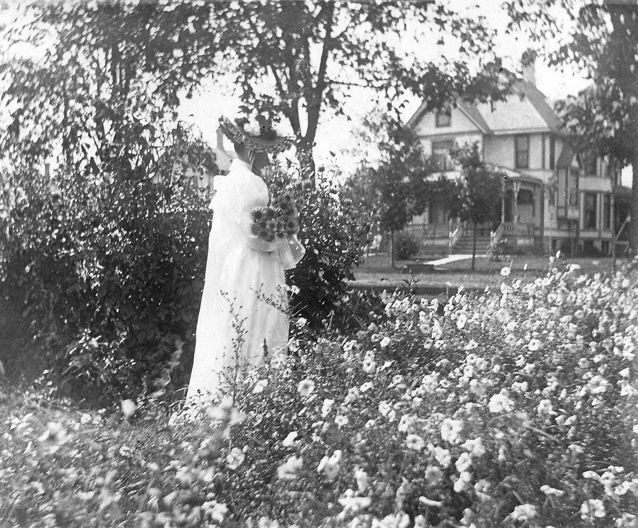 Happier days at the Fargo Mansion: Addie stands  amongst a bower of flowers.