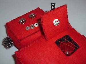 Close-up of the chest of a robot doll made from red felt. Image hosted by Photobucket.com