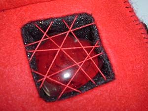 Close-up of the chest of a robot doll made from red felt, with a resin heart inside a cavity. Image hosted by Photobucket.com