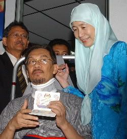 BEBAS BERLEPAS.... Dato' Seri Anwar Ibrahim tersenyum menunjukkan pasport antarabangsanya yang diluluskan sambil diperhatikan oleh isterinya, Datin Seri Wan Azizah di pejabat Imigresen, Pusat Bandar Damansara pada jam 10.45 pagi tadi (3 September). Foto Wan Zahari. HarakahDaily