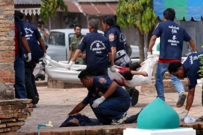 A Thai charity worker examines the body of a Thai-Muslim militant who were among 34 killed in the fighting with Thai security officers at Krue Se mosque in Pattani province, southern Thailand Wednesday, April 28, 2004. AP