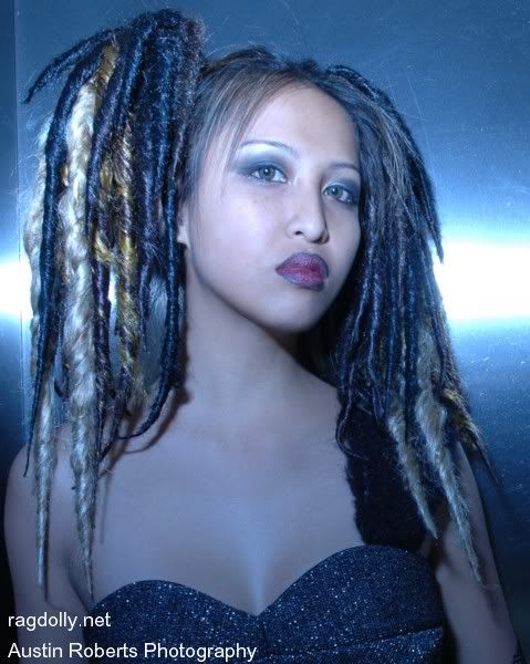 Model Loan is wearing dread clips of a dark brown base with gold black 