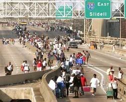 People affected by Hurricane Katrina walk on the elevated freeway in downtown New Orleans