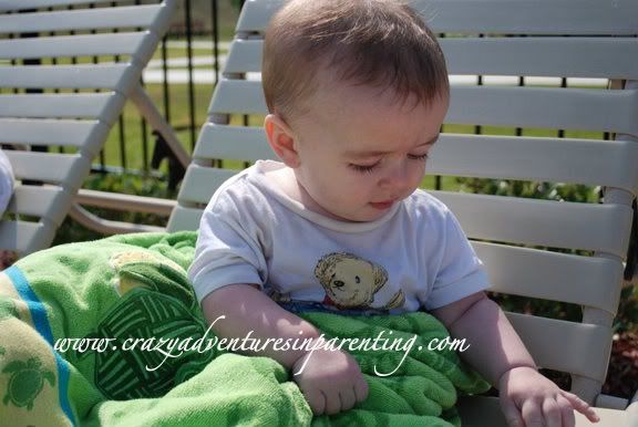 infant wrapped in towel on chair