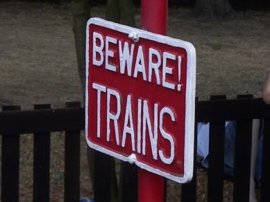 I think this is more to warn the trains that giant clumsy humans might damage them rather then warn people there are trains moving around...though i suppose that a kid could get hurt quite badly...