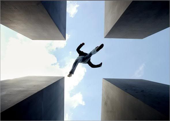 A visitor jumps from one pillar to another on part of the Holocaust memorial in Berlin, Germany, on May 16