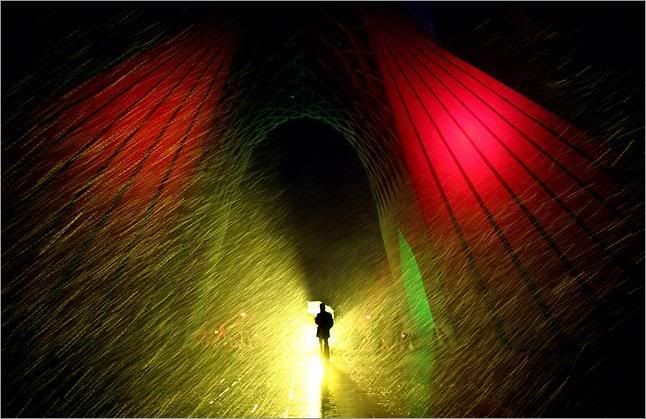 An Iranian woman walks through the snow during a cold winter night at Azadi (Freedom) Square west of Tehran on Feb 7
