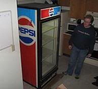 Derek standing next to his new refrigerator in our kitchen