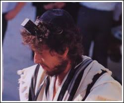 Bob Dylan com kippá, tallit e tefilin, adereços litúrgicos judaicos, frente ao Kotel, o Muro das Lamentações, em Jerusalém