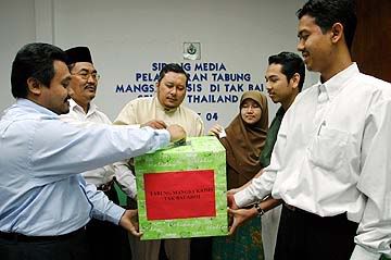 AHMAD AZAM (tengah) memasukkan wang ke dalam Tabung Khas Tak Bai, bersama-sama wakil penderma lain bagi membantu keluarga mangsa yang maut dalam rusuhan - Gambar oleh Hasriyasyah Sabudin