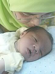 Baby Amirul Naim getting tender loving care from Kak Siti in Kuala Lumpur on Wednesday. His mother, a snatch theft victim, has been in a coma since Oct 20. - STARpic by Kevin Tan