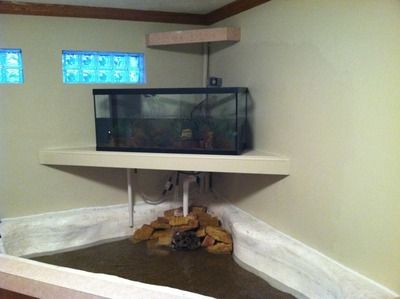 Inside aquarium and pond Aquarium and stand installed over an indoor pond