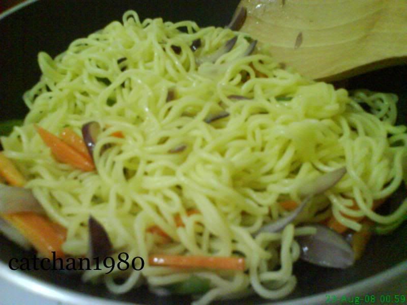 3. Add the noodles to the pan, then pour about 1/4 cup of water. Gently separate the noodles while incorporating the meat and vegetables with the noodles.
