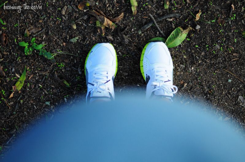 looking down at pregnant belly while on a walk