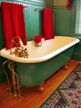 claw foot bath tub against green wall