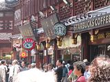 A Dairy Queen and a Starbucks share frontage with a dumpling shop in the Yu Gardens tourist shopping district.