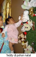 Izqa dengan pohon natal yang dihiasi oleh boneka² termasuk teddy