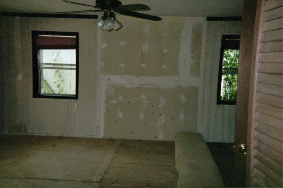 Another masterbedroom view. This room is 15x15 . The old wallpaper is gone and the falling down paneling. The windows have been squared up mostly and room painted