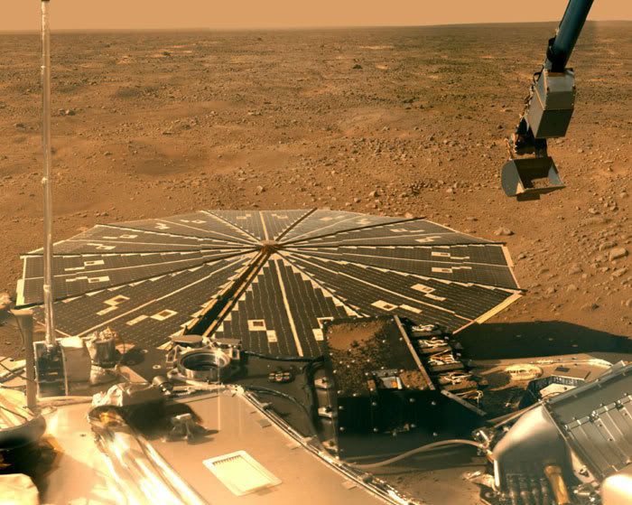 The Martian northern plain, with one of Phoenix's solar panels and a portion of the lander's flight deck visible in the foreground.