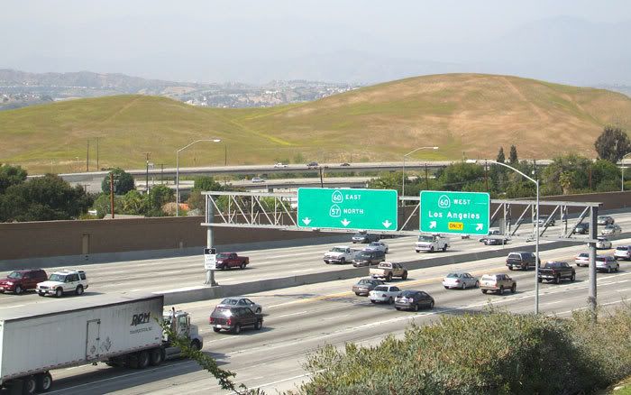 In this photograph that I took on 4/24/08, rush hour traffic begins to form on the 57 and 60 freeways.  Beyond them are the hills, nicknamed 'The Boonies', where the Los Angeles Football Stadium would be located if it was built.