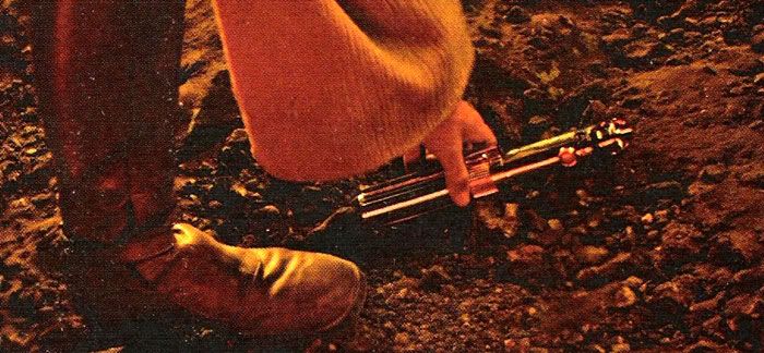 Obi-Wan picks Anakin's lightsaber up from the black sand in REVENGE OF THE SITH.