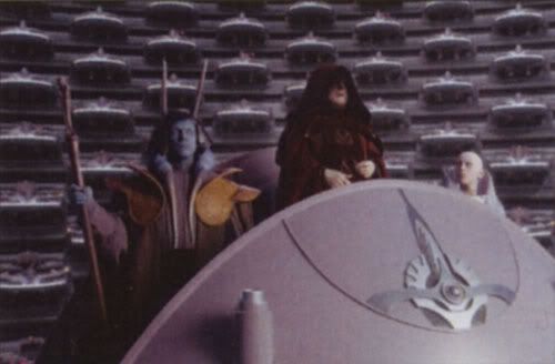 Darth Sidious, dressed in his Chancellor robe, addresses the Galactic Senate.