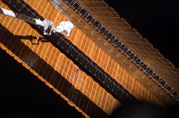 Astronaut Scott Parazynski does repair work on one of the International Space Station's port-side solar panel wings during a spacewalk today.