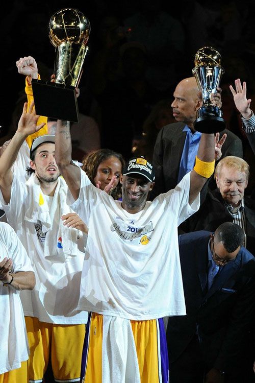 Kobe Bryant hoists up the NBA championship trophy and his 2nd Finals MVP trophy after he leads the Lakers to its 16th title, on June 17, 2010.