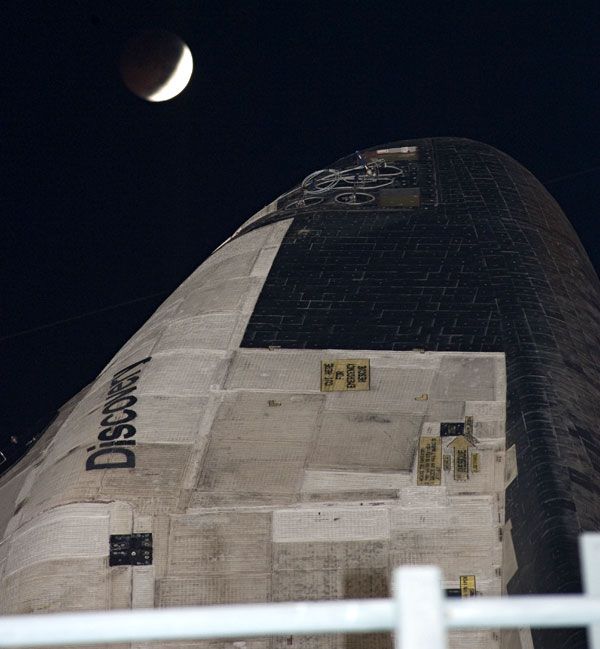 A total lunar eclipse is about to take place above space shuttle Discovery on the night of December 20, 2010.
