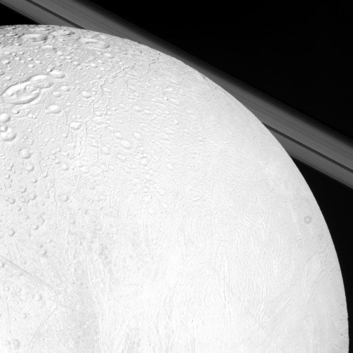 An image, taken by NASA's Cassini spacecraft, of Saturn's moon Enceladus with the planet's rings in the background.