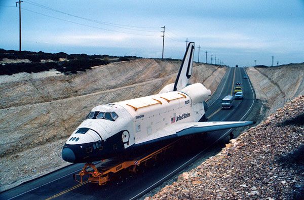 Space shuttle Enterprise is driven through rocky terrain at Vandenberg AFB in California.
