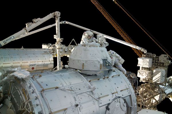 Spacewalking astronauts Robert Behnken (top) and Nicholas Patrick prepare to 'unwrap' the Cupola onboard the International Space Station.