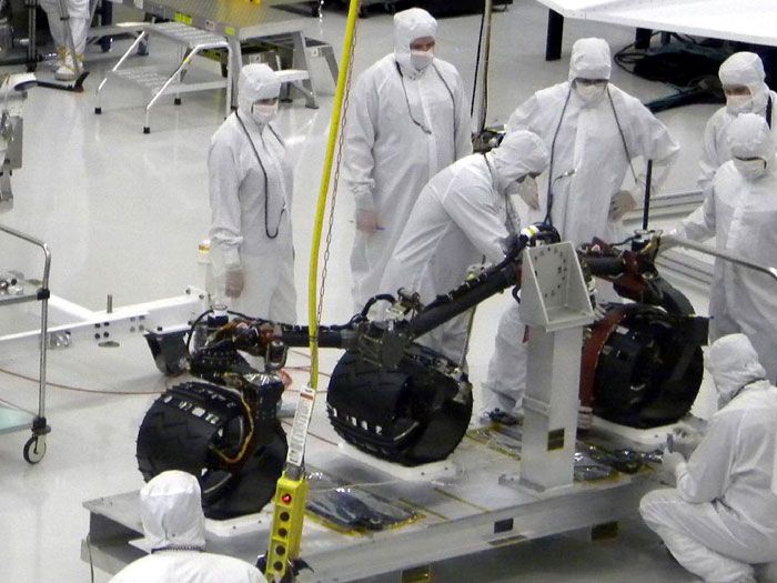 NASA JPL engineers prepare three of the CURIOSITY Mars Rover's six wheels for installation on June 29, 2010.