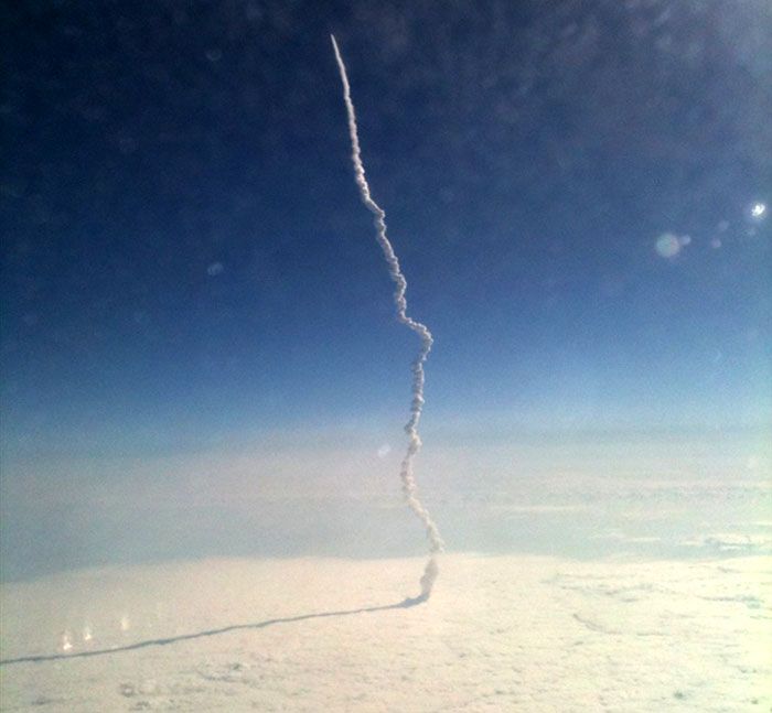 As seen onboard a passing airliner, space shuttle Endeavour emerges from a cloud deck after launching from Kennedy Space Center in Florida on her final voyage to the International Space Station, on May 16, 2011.