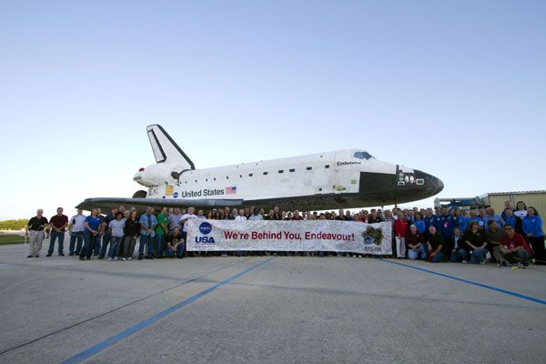 Kennedy Space Center workers take a group photo with space shuttle Endeavour during her rollover to the VAB, on February 28, 2011.