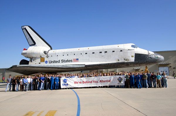 Kennedy Space Center workers take a group photo with space shuttle Atlantis during her rollover to the VAB, on May 17, 2011.