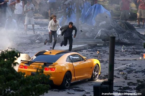 Shia and Rosie run towards Bumblebee as the Autobot comes to the rescue in TRANSFORMERS 3.
