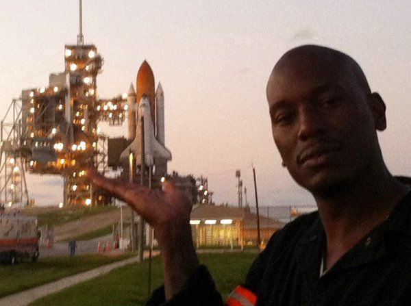 Actor/rapper Tyrese Gibson poses in front of space shuttle Discovery at Launch Complex 39A.