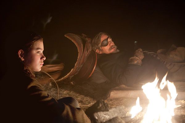 Mattie Ross (Hailee Steinfeld) and Rooster Cogburn (Jeff Bridges) take a rest during their trip to find and capture the man who killed Ross' father in TRUE GRIT.