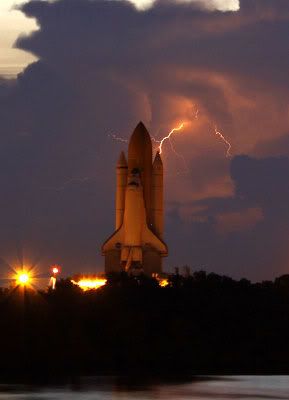Lightning flashes in the distance as space shuttle Discovery rolls out to Launch Complex 39A at Kennedy Space Center...on August 4, 2009.